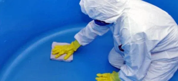 Técnico realizando higienização de caixa d'água